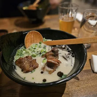 a bowl of ramen with a wooden spoon