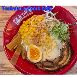 a plate of ramen noodles with an egg and a side of corn