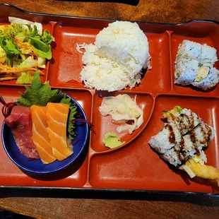 Bento box with tempura  roll and sashimi.