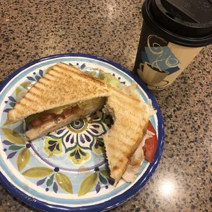a plate with a sandwich and a cup of coffee