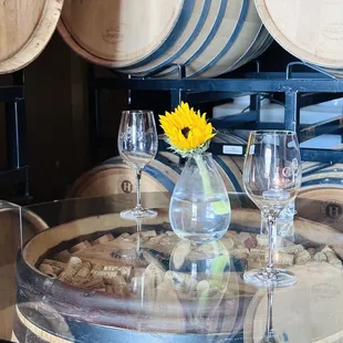 a table with wine glasses and a sunflower