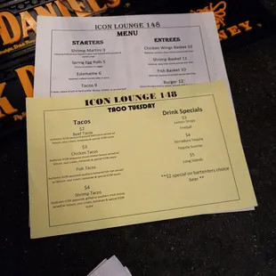 a menu and a drink on a table