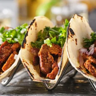 three tacos on a wire rack
