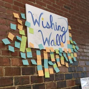 a brick wall with sticky notes attached to it