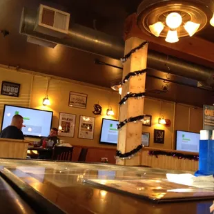 a bar with two televisions in the background