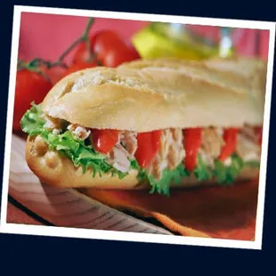 a sub sandwich with tomatoes and lettuce