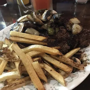 ows a plate of french fries and steak