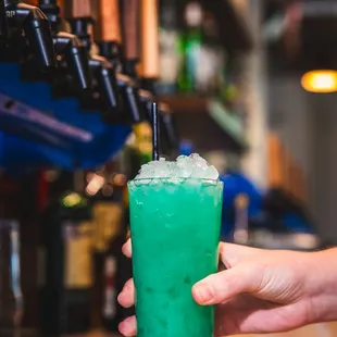 a hand holding a green drink
