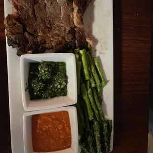 Rib eye grilled to perfection with chimichurri and romesco sauces. Nice serving of grilled asparagus