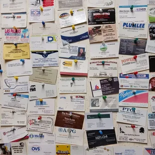 a bulletin board covered in business cards