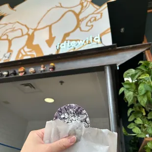 a hand holding a donut