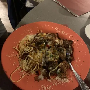 a plate of spaghetti with meat and vegetables
