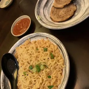 a plate of noodles and bread on a table