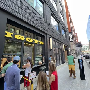 a group of people standing outside of a store