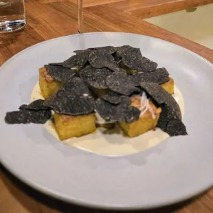 Roman Style Semolina Gnocchi with a Taleggio fondue, Australian black truffles, shallots, and sherry vinegar reduction