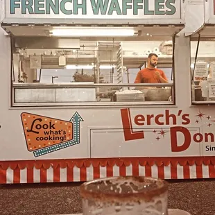a pint of beer in front of a french waffles truck
