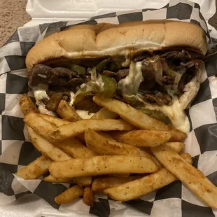 a sandwich and fries in a styrofoam container