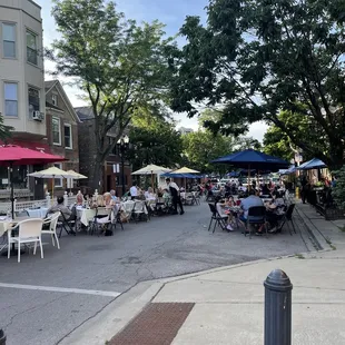 Outdoor dining shared by the two or three restaurants on the block black chairs are Ignotz