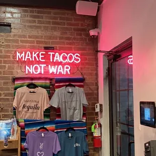 a neon sign that says make tacos not war
