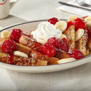 a plate of french toast with strawberries and bananas