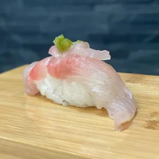 a piece of sushi on a cutting board