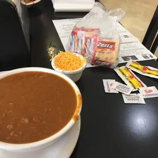 a bowl of chili and a bag of chips