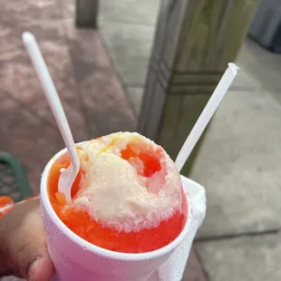 a hand holding a cup of ice cream