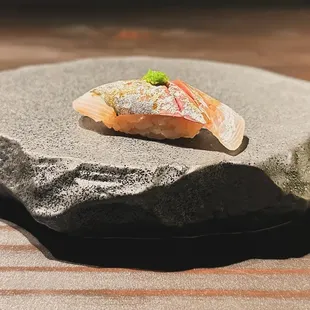 a piece of sushi on a rock