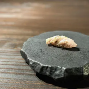 a small piece of food on a black plate