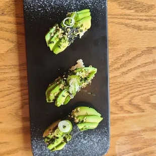 A small plate with avocado and scallion, a bite provided by the restaurant.