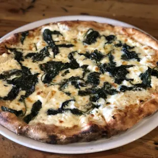 Il Bosco wood fired Artesian thin crust spinach, garlic and our NEW &quot;Follow your Heart&quot; VEGAN cheese on a white base.  Simply perfect