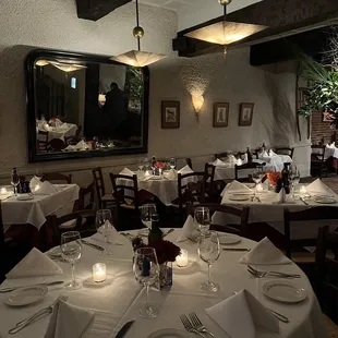a dining room with white tablecloths and place settings