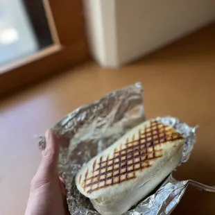 a hand holding a sandwich