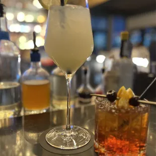 a cocktail and a drink on a bar