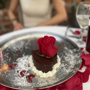 Chocolate heart shaped cake for dessert with rose ascent.