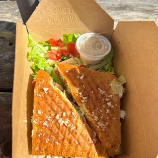 a sandwich and salad in a box