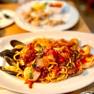 a plate of pasta with musselling and clams