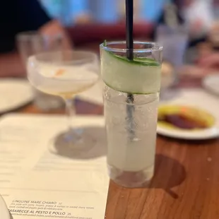 a glass of water with a slice of cucumber in it