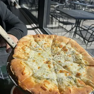 a person holding a pizza