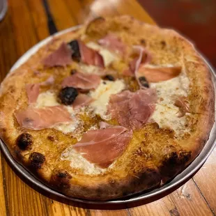 a pizza with ham and olives