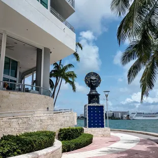 a clock on a pedestal in front of a building