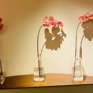 three vases with flowers in them