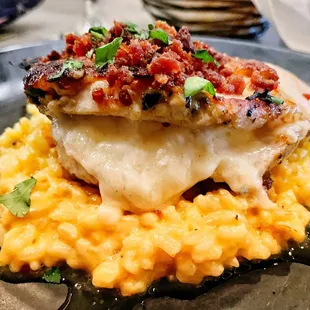 Pancetta covered chicken dish over risotto