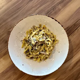 a plate of pasta on a wooden table