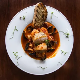 Cacciucco, Grilled NC shrimp, mussels, braised calamari, seared scallops ,roasted garlic,  red chili paste, tomato, crostini