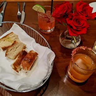 a basket of bread and a glass of orange juice