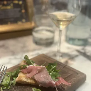 Prosciutto e focaccia appetizer. 20 year aged prosciutto, amazing cheese, fresh focaccia, arugula tossed in olive oil.