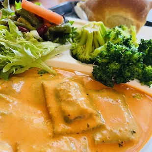 Asparagus ravioli is tomato cream sauce, brocolli with chilli, salad and bread