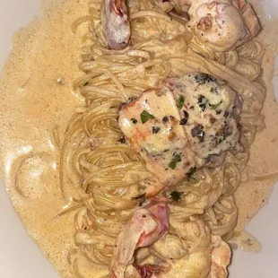 a plate of pasta with shrimp and sauce