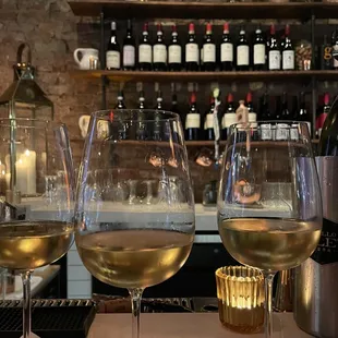 three glasses of wine on a bar